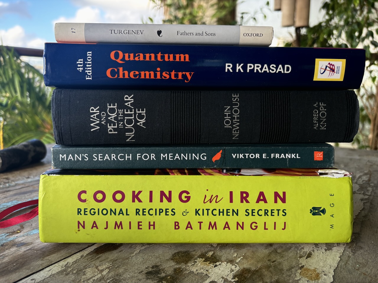 A stack of books: Quantum Chemistry, Turgenev, War and Peace in the Nuclear Age, Man's Search for Meaning, Cooking in Iran